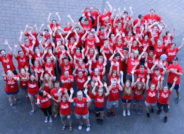 Eine Gruppe von fröhlichen Menschen in roten Volunterrshirts.